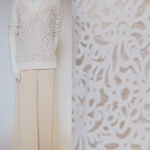 Mannequin wearing a white cashmere cut out top and beige pants 
