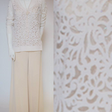 Mannequin wearing a white cashmere cut out top and beige pants 
